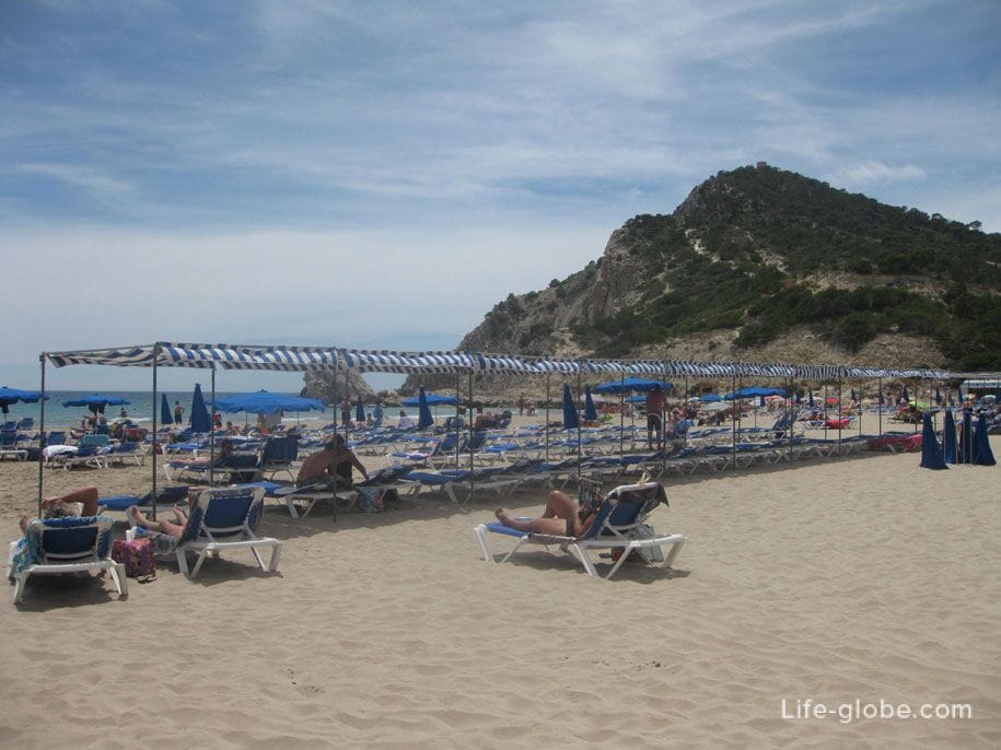 Шезлонги и зонты от солнца на пляже Финестрат, Испания